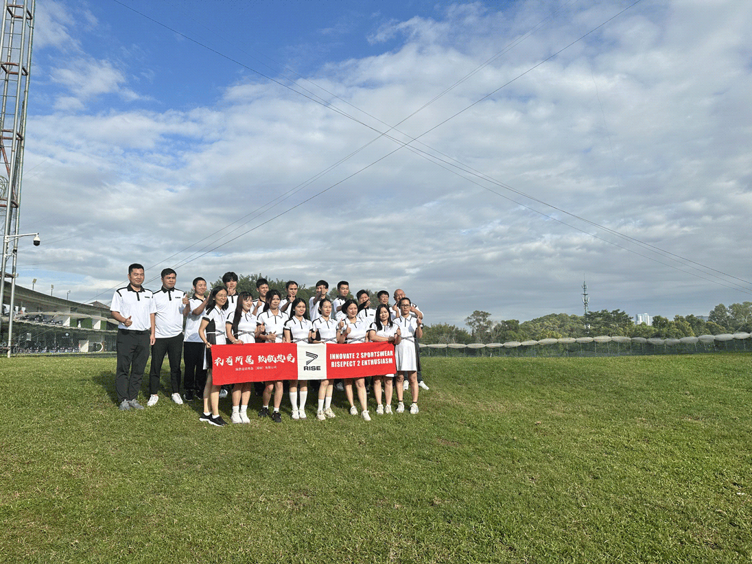 Rise Sportswear employees pose on the golf course with banners