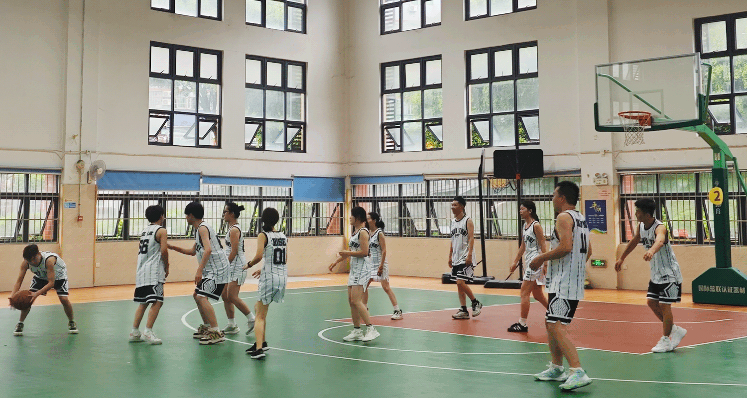 A player dribbles the ball during the RISE basketball group match as ten others focus on him—some blocking opponents, others guarding the hoop.